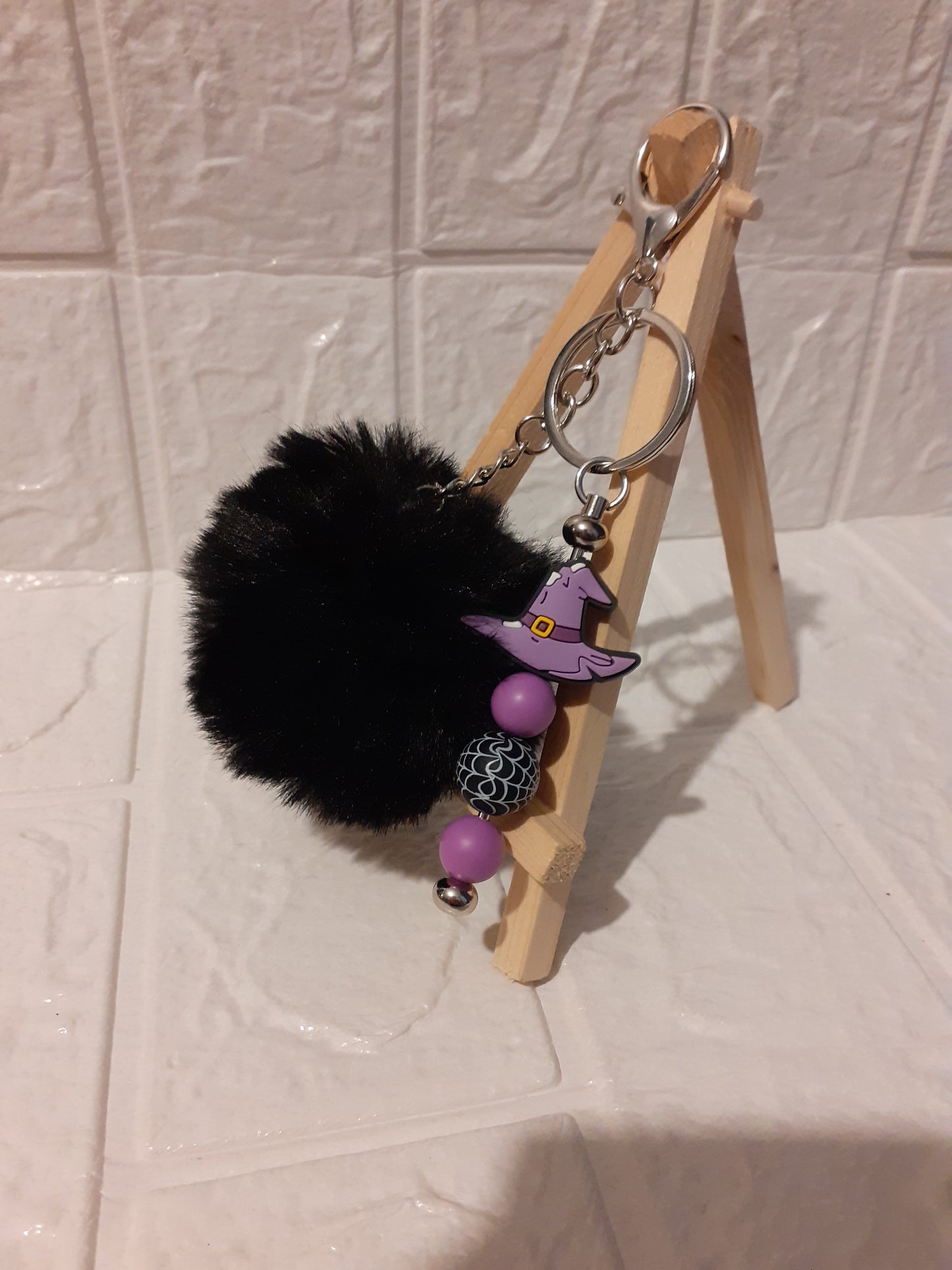 silver witch hat keychain with black pom pom